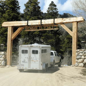 trailering tips before you hit the road (picture of a truck pulling a horse trailer down a dirt driveway)