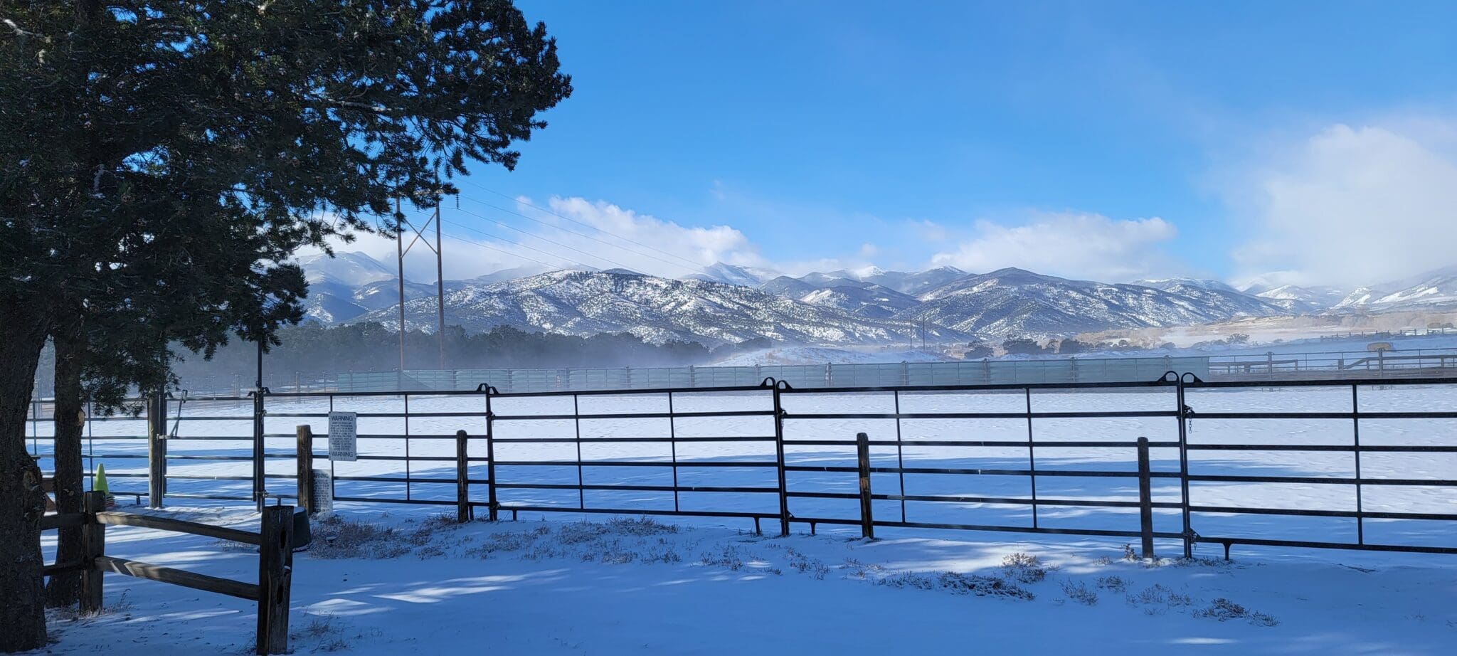 Julie's arena blanketed in snow with the mountains in the background.